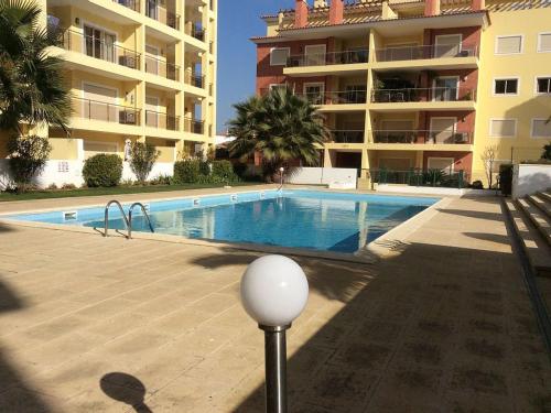 a swimming pool in front of a apartment building at HENRI'S APARTMENTS - Pátio do Convento in Lagos