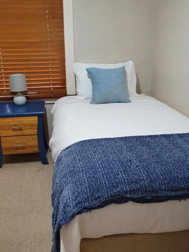 a neatly made bed with white sheets and pillows at Denison Lodge in Mudgee