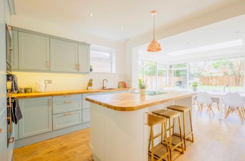 a kitchen with white cabinets and a large island with bar stools at Gorgeous Luxury Chalet, New Forest & Coast & in Hordle