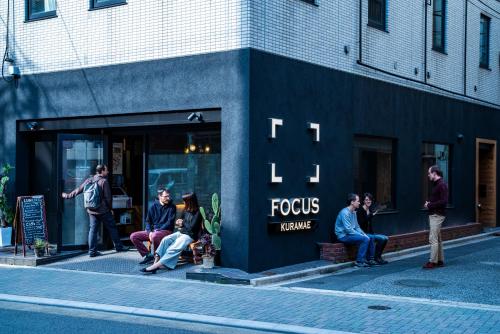 a group of people sitting outside of a store at Focus Kuramae in Tokyo