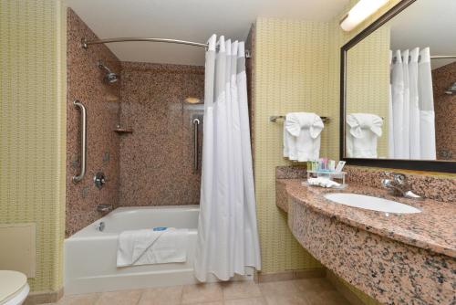 a bathroom with a tub and a sink and a toilet at Holiday Inn Express Woodland, an IHG Hotel in Woodland