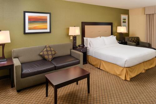 a hotel room with a bed and a couch at Holiday Inn Express Woodland by IHG in Woodland