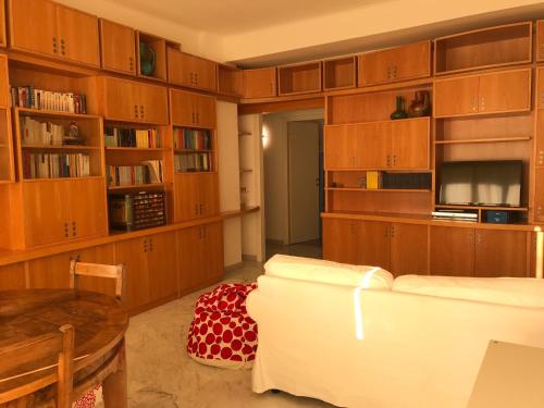 uma sala de estar com armários de madeira e um sofá branco em Questa casa non è un albergo CIU-ATR 9390-9 em Roma