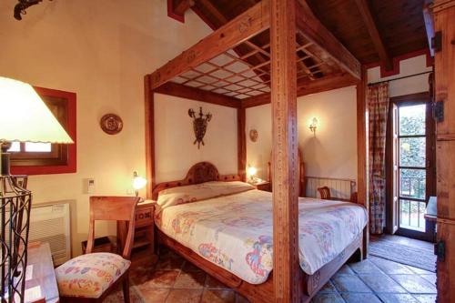 1 dormitorio con cama de madera con dosel en una habitación en Hotel Amanhavis, en Benahavís