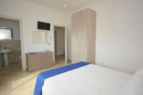 a bedroom with a white bed and a sink at da Rocco B&B in Sant'Isidoro