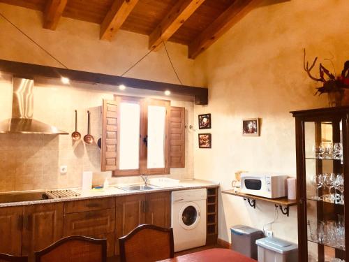 a kitchen with a sink and a washing machine at La Casa del Cartero Pablo in Saldaña de Ayllón