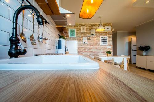 a large bath tub in a kitchen with a table at Grand Apartments - Apartment on the 17th floor with panorama in Gdańsk