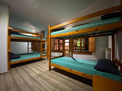 a room with three bunk beds in it at Albergue Pereiro in Melide