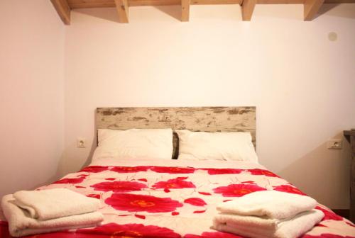 a bedroom with a bed with red flowers on it at EVANNA HOUSE in Symi