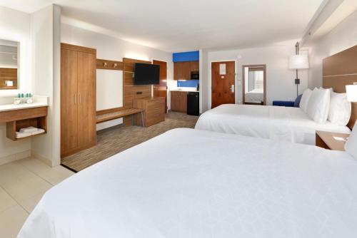 a hotel room with two beds and a television at Holiday Inn Express & Suites Irving Conv Ctr - Las Colinas by IHG in Irving