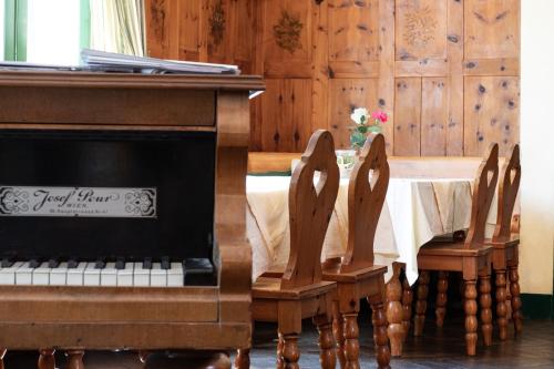 pianino siedzące obok stołu z w obiekcie Hotel Bergwirt Schönbrunn w Wiedniu