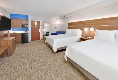 a hotel room with two beds and a flat screen tv at Holiday Inn Express & Suites Irving Conv Ctr - Las Colinas by IHG in Irving