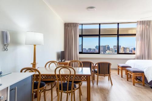 a hotel room with a table and chairs and a bed at Gardens Centre Holiday Apartments in Cape Town