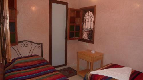 Habitación pequeña con cama y ventana en Hotel Aday, en Marrakech