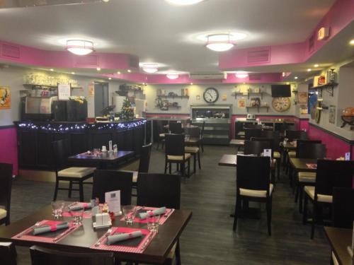 une salle à manger avec des tables et des chaises ainsi qu'un bar dans l'établissement initial by balladins Amiens / Longueau, à Longueau