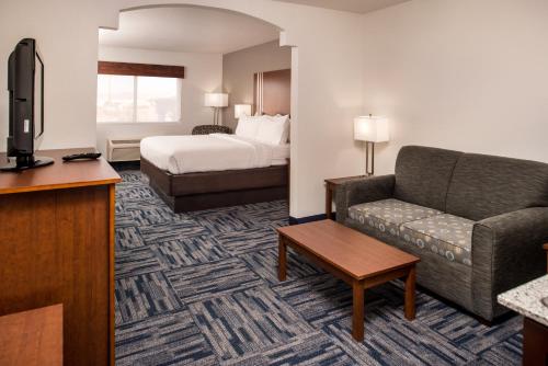 a hotel room with a bed and a couch at Holiday Inn Express & Suites Alamogordo Highway 54/70 by IHG in Alamogordo