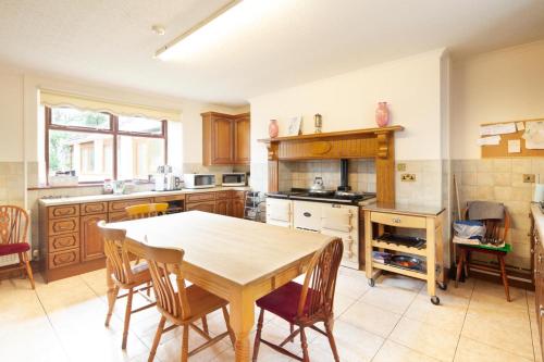 a kitchen with a table and chairs in it at Penrhadw Farm in Merthyr Tydfil