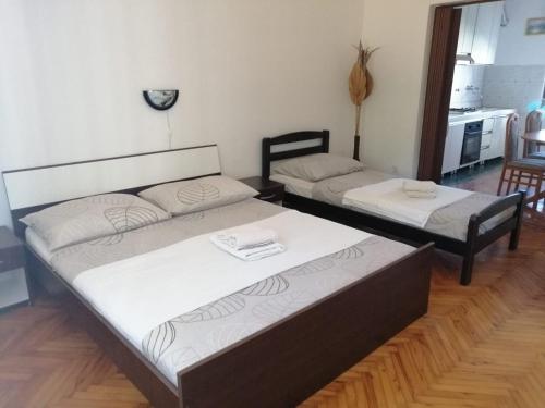 2 Betten im Wohnzimmer mit Küche in der Unterkunft Apartments Anka - comfortable and affordable in Marina