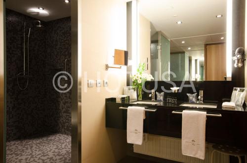 a bathroom with a sink and a shower and a mirror at Gran Hotel La Perla in Pamplona