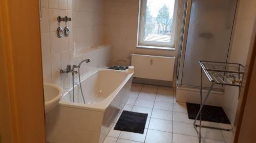 a bathroom with a bath tub and a sink at cosy apartment in Neupetershain with Wifi in Neupetershain