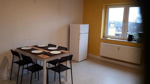 a kitchen with a table and chairs and a refrigerator at cosy apartment in Neupetershain with Wifi in Neupetershain