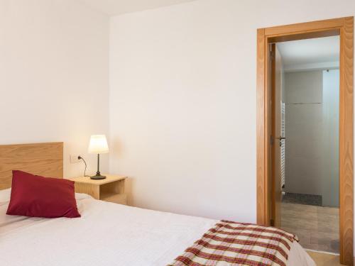 a bedroom with a bed with a red pillow at Villa romani in Can Picafort