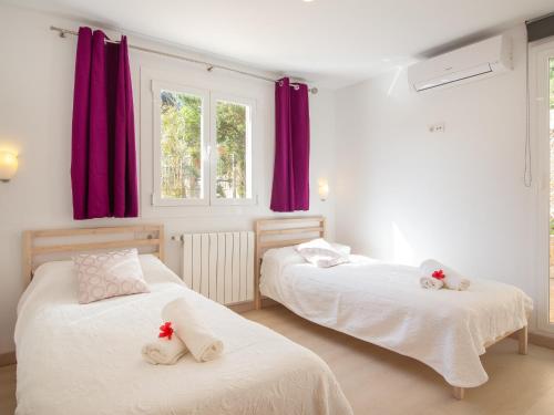 - 2 lits dans une chambre dotée de rideaux rouges dans l'établissement Villa romani, à Can Picafort