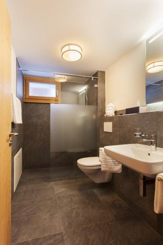 a bathroom with a toilet and a sink at Apartment Bristolino in Saas-Fee