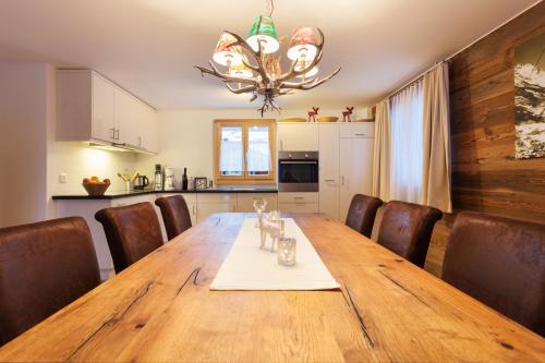 a dining room table with chairs and a chandelier at Apartment Bristolino in Saas-Fee