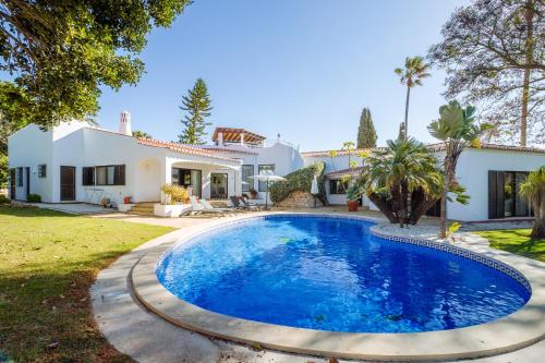 a swimming pool in front of a house at Casa Shambala in Carvoeiro