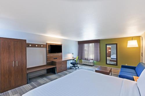 a hotel room with a bed and a flat screen tv at Holiday Inn Express Hotel & Suites Dallas Lewisville by IHG in Lewisville