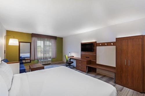 a hotel room with a large bed and a desk at Holiday Inn Express Hotel & Suites Dallas Lewisville by IHG in Lewisville