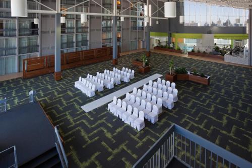un salón de banquetes con sillas y mesas blancas en un edificio en Holiday Inn Burlington Hotel & Conference Centre, an IHG Hotel, en Burlington