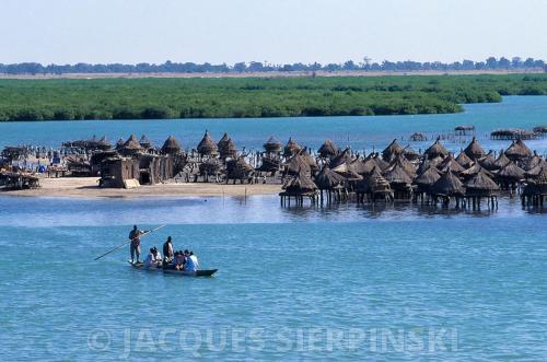 a group of people in a boat in the water at Auberge Cœur Océan in Joal-Fadiout