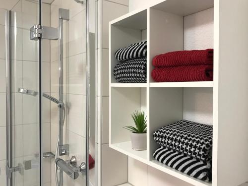 a bathroom with shelves with towels and a shower at Ferienwohnung Sterntaucher in Überlingen