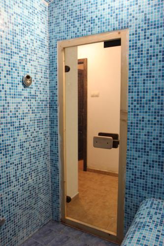 a mirror in a bathroom with blue tiles at New Bakalov House in Bozhentsi