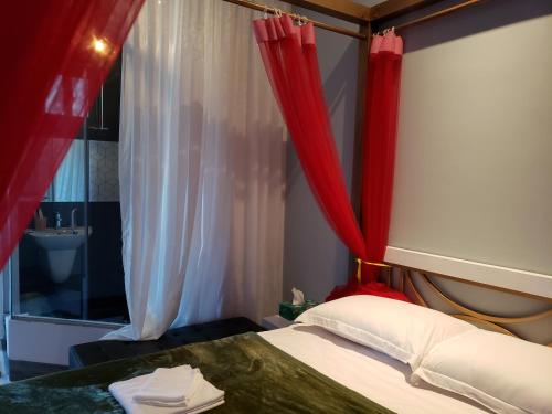 a bedroom with a bed with red curtains and a window at Biên Hòa Hotel in Bien Hoa