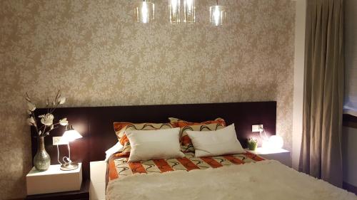 a bedroom with a large bed with two night stands at Varosha Combarro in Combarro