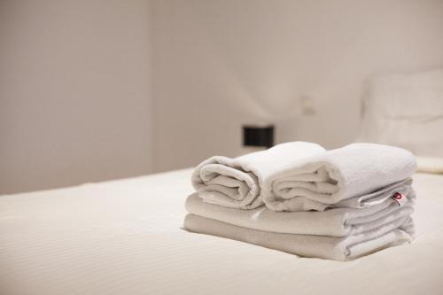 a stack of towels sitting on a bed at Smartflats - Bourse Brussels in Brussels