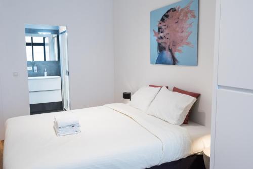 a bedroom with a large bed with white sheets at Smartflats - Bourse Brussels in Brussels