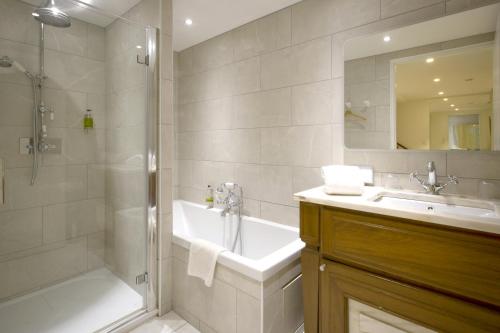 une salle de bain avec une baignoire, une douche et un lavabo dans l'établissement Villa Segur, à Bordeaux