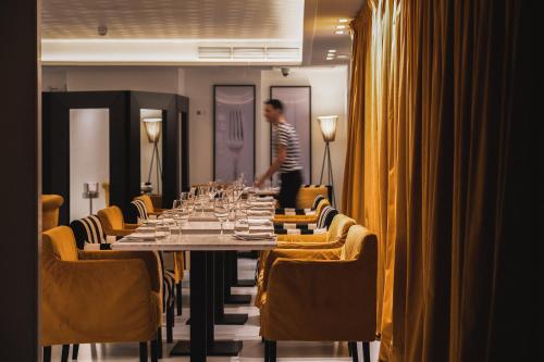 a man standing in front of a long table with wine glasses at Puro Hotel Oasis Urbano in Palma de Mallorca