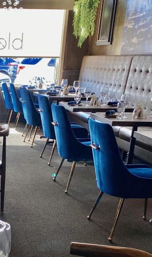 a row of tables and chairs with wine glasses on them at Inn on Main Hotel in Manasquan