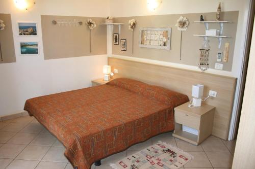 een slaapkamer met een bed met een oranje sprei bij Leme Bedje fronte spiaggia in Santa Maria