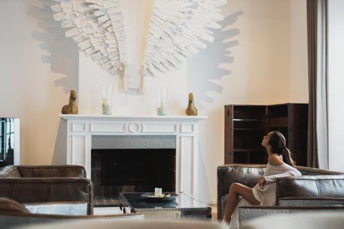 a woman sitting in a chair in front of a fireplace at Puro Hotel Oasis Urbano in Palma de Mallorca