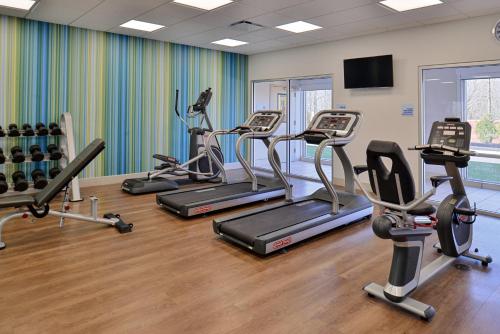 a gym with several treadmills and cardio machines at Holiday Inn Express & Suites - Southgate - Detroit Area by IHG in Southgate