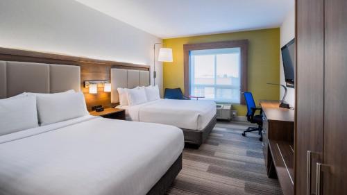 a hotel room with two beds and a desk at Holiday Inn Express Airdrie by IHG in Airdrie