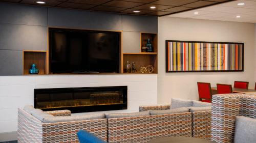a waiting room with couches and a flat screen tv at Holiday Inn Express Airdrie by IHG in Airdrie