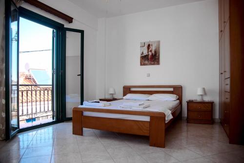 a bedroom with a bed and a large window at Maxis apartment 4 in Koroni