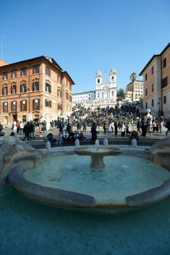 a group of people sitting around a fountain at Harry's Bar Trevi Luxury Apartments - Spagna in Rome
